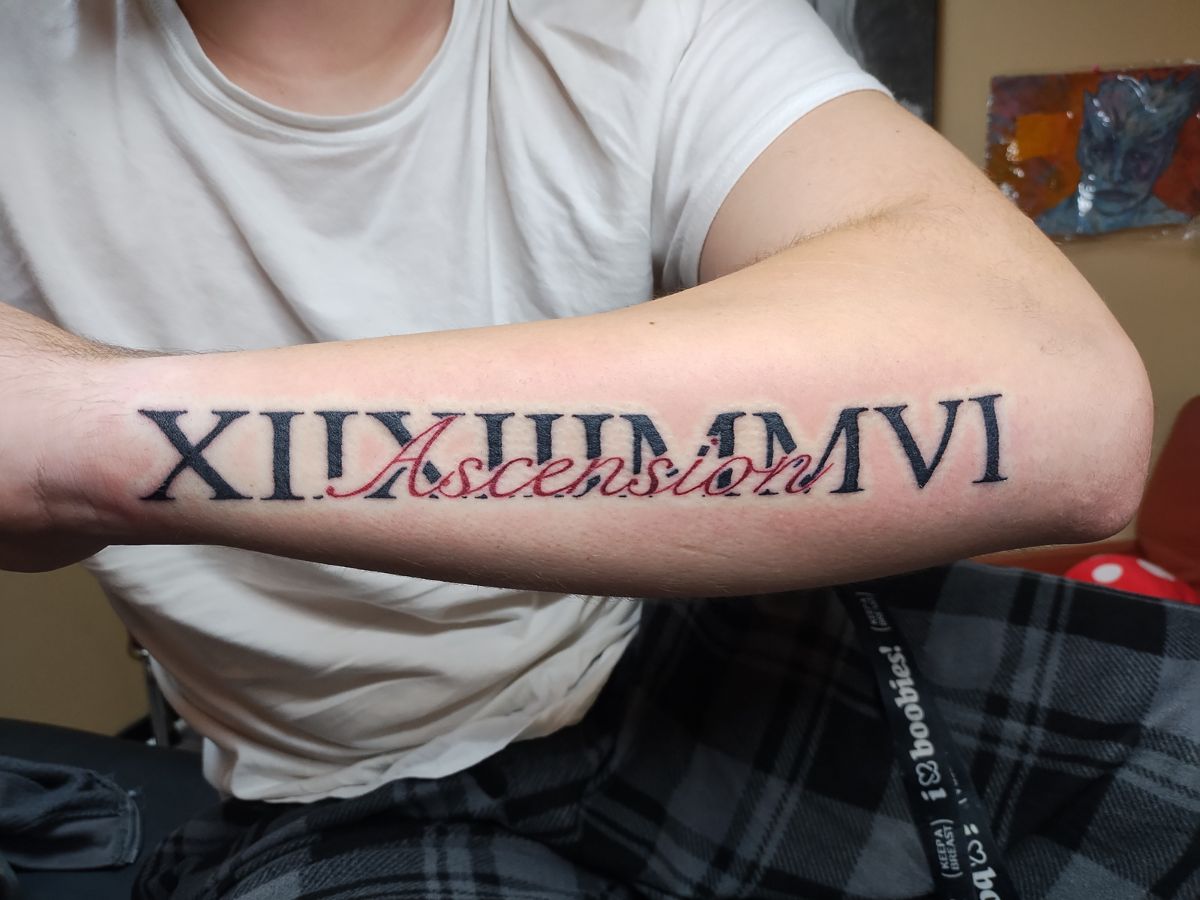 Black and red script tattoo by Courtney at Earth’s Edge Tattoo & Piercing