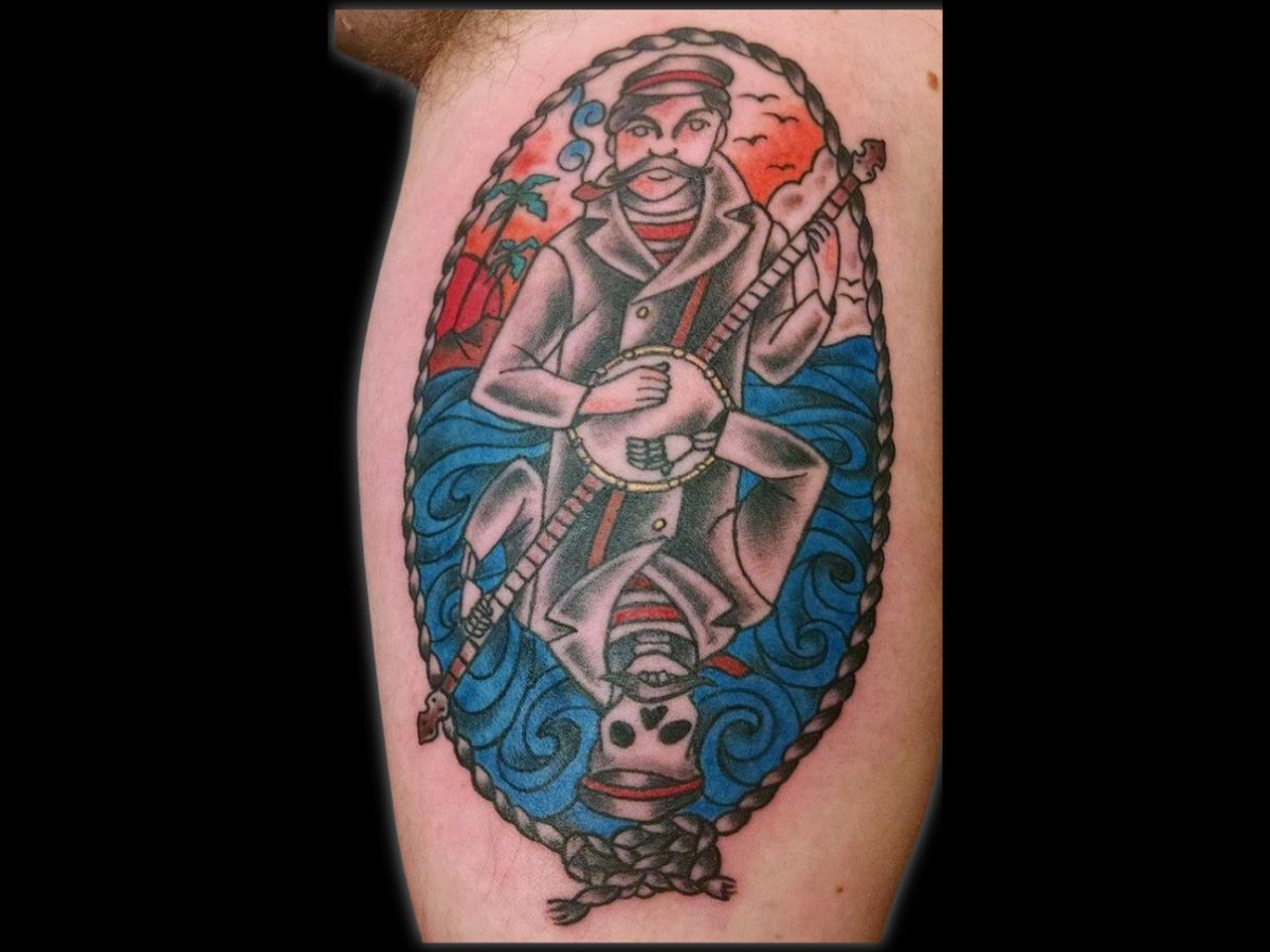 Sailor with banjo traditional tattoo by Greg — bold lines and classic color.
