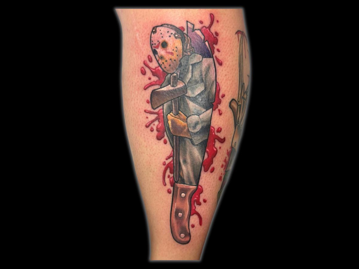 Jason mask and knife tattoo by Robert — horror realism with contrast shading.