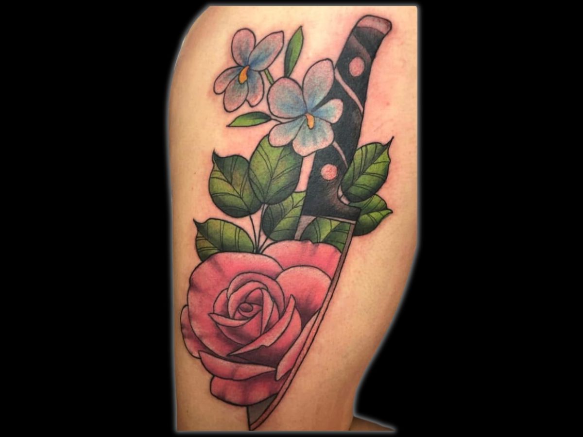 Knife through rose tattoo by Robert — classic traditional motif.