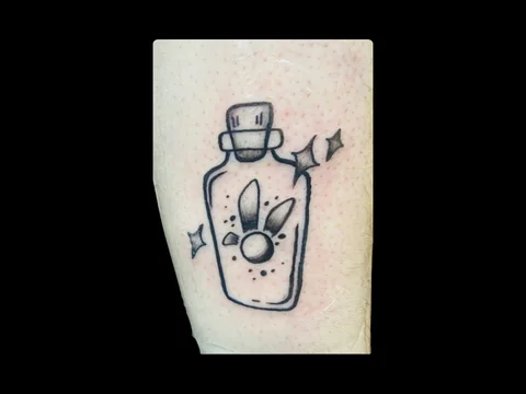 Dainty potion bottle tattoo by Sharlotte K. at Earth’s Edge Tattoo & Piercing in Winston-Salem, NC